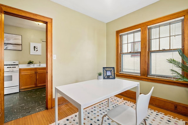 office space with light hardwood / wood-style floors and sink