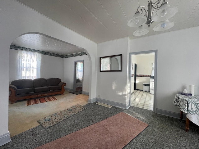 carpeted living room with a chandelier