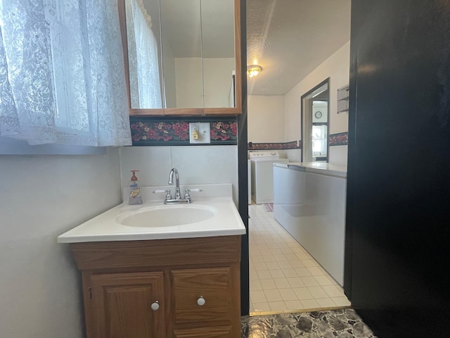 bathroom featuring vanity and washer and clothes dryer