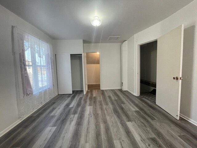 unfurnished bedroom with dark hardwood / wood-style flooring