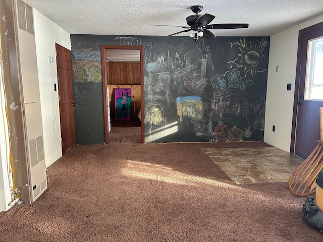 carpeted living room with ceiling fan and a textured ceiling