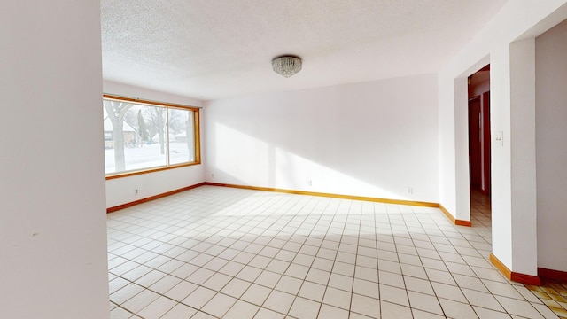 tiled spare room with a textured ceiling