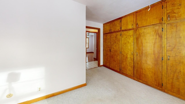 unfurnished bedroom featuring light colored carpet and a closet