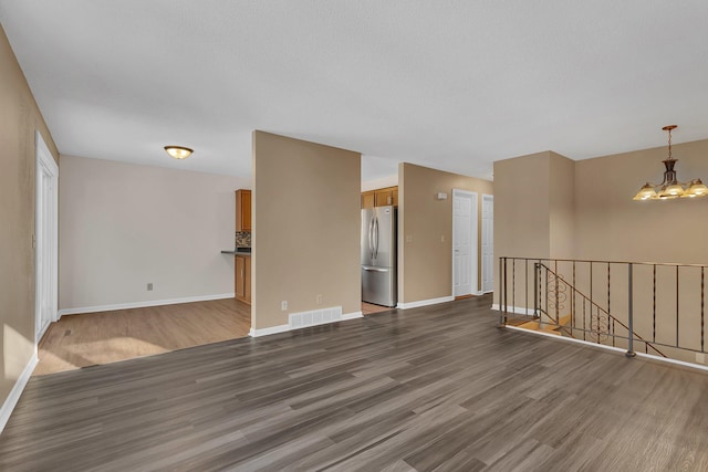 unfurnished room featuring dark hardwood / wood-style floors and a chandelier