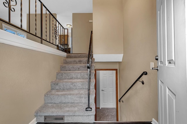 stairs featuring baseboards and visible vents