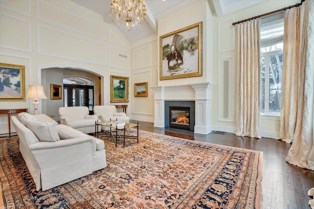 living room with crown molding, dark wood-type flooring, high vaulted ceiling, and a chandelier