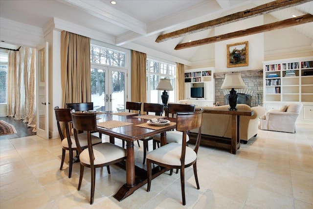 dining room with a stone fireplace, high vaulted ceiling, beamed ceiling, ornamental molding, and french doors