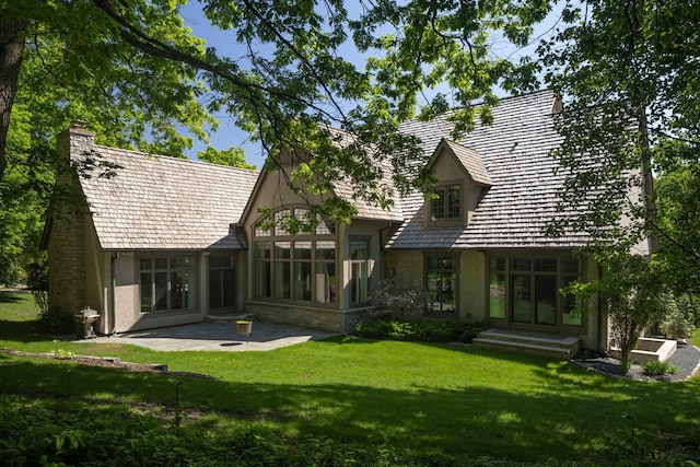 back of house with a sunroom, a patio area, and a lawn