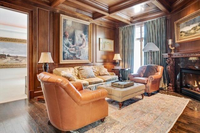 sitting room with wooden walls, coffered ceiling, a fireplace, ornamental molding, and beamed ceiling