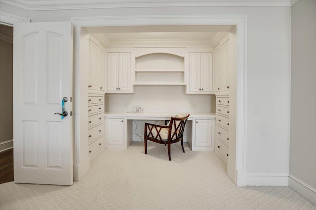 carpeted office with ornamental molding and built in desk