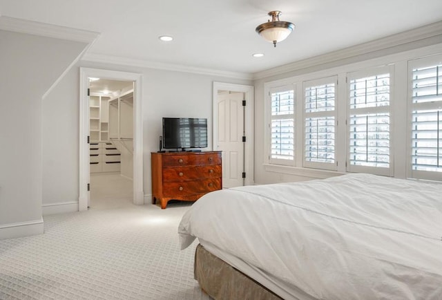 bedroom featuring a walk in closet, ornamental molding, and light colored carpet