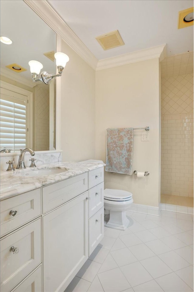 bathroom featuring tiled shower, toilet, ornamental molding, vanity, and tile patterned flooring