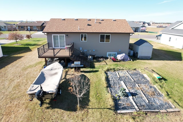 rear view of property featuring a yard, a storage shed, and a wooden deck