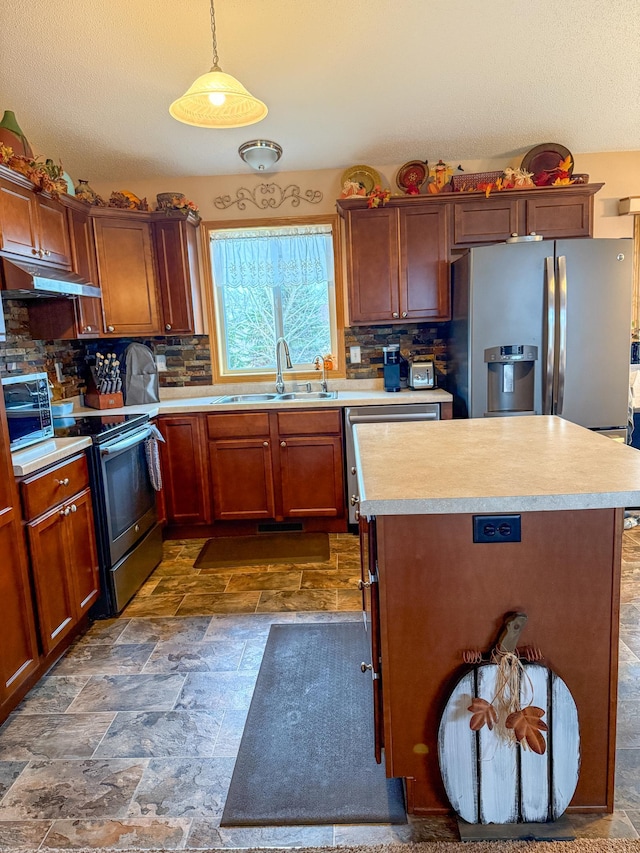 kitchen featuring decorative backsplash, pendant lighting, appliances with stainless steel finishes, and sink