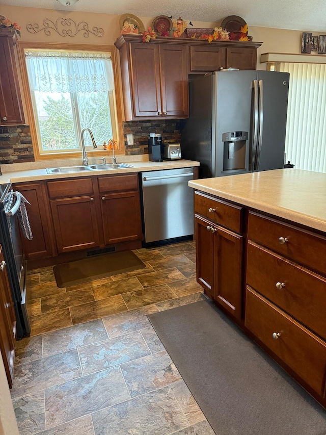 kitchen with decorative backsplash, sink, and stainless steel appliances