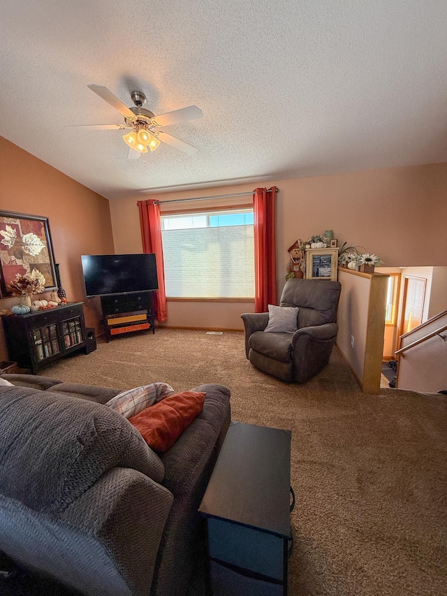 living room featuring carpet, a textured ceiling, and ceiling fan