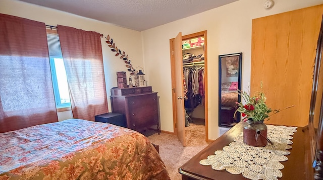 bedroom featuring light carpet, a textured ceiling, and a closet