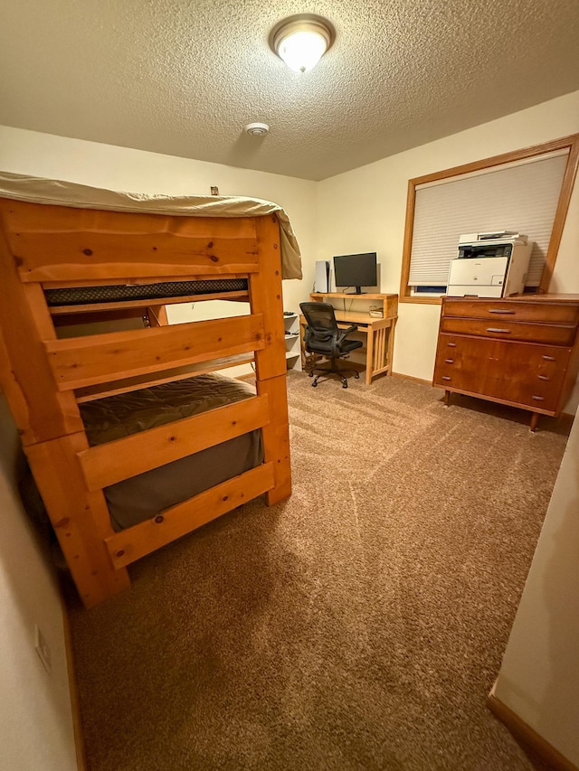 bedroom with a textured ceiling and dark carpet