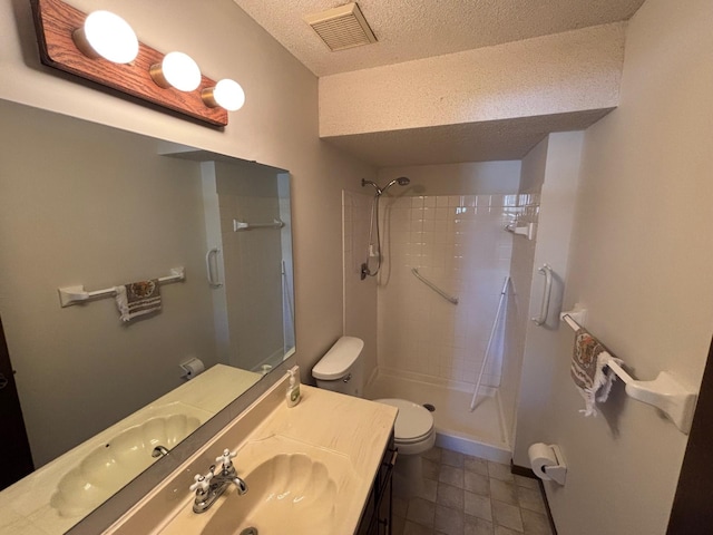 bathroom featuring tile patterned flooring, vanity, walk in shower, toilet, and a textured ceiling