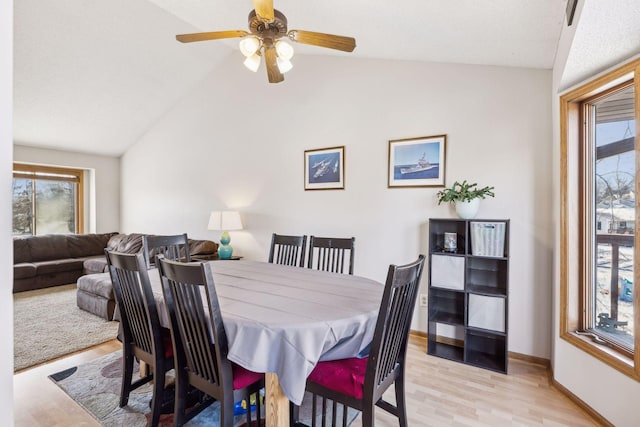 dining area with light hardwood / wood-style floors, ceiling fan, and lofted ceiling