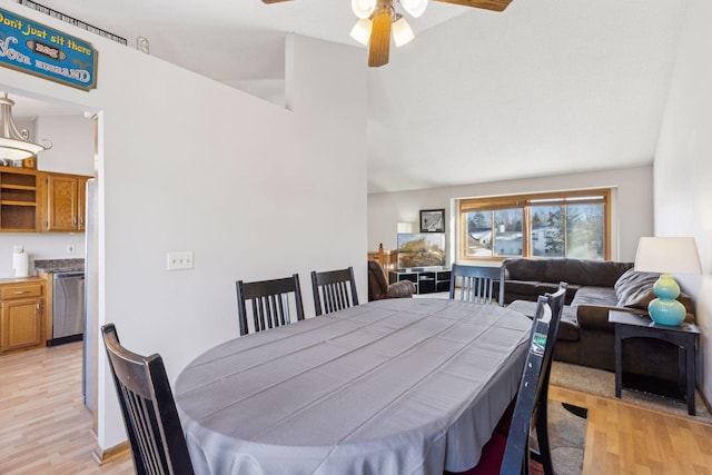 dining area with ceiling fan, high vaulted ceiling, and light hardwood / wood-style floors