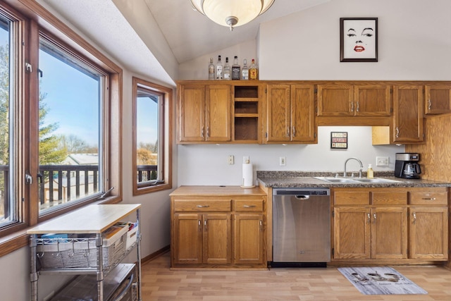 kitchen featuring dishwasher, light hardwood / wood-style floors, sink, and vaulted ceiling