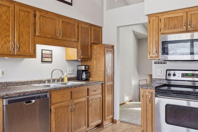 kitchen with stainless steel appliances, light hardwood / wood-style flooring, and sink