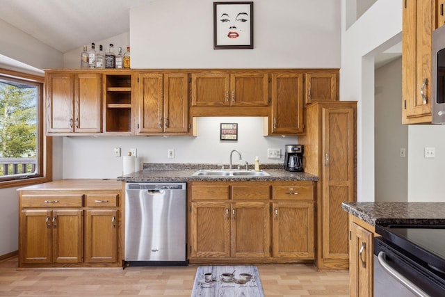 kitchen featuring sink, stainless steel appliances, vaulted ceiling, and light hardwood / wood-style flooring