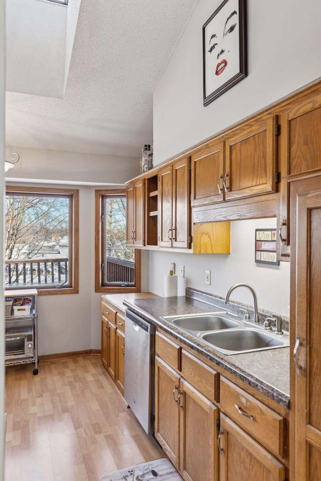 kitchen featuring dishwasher, light hardwood / wood-style flooring, a textured ceiling, and sink