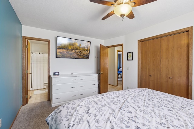 bedroom featuring a textured ceiling, ensuite bathroom, ceiling fan, and light colored carpet