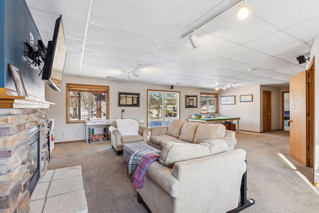 carpeted living room with a stone fireplace, a paneled ceiling, and billiards