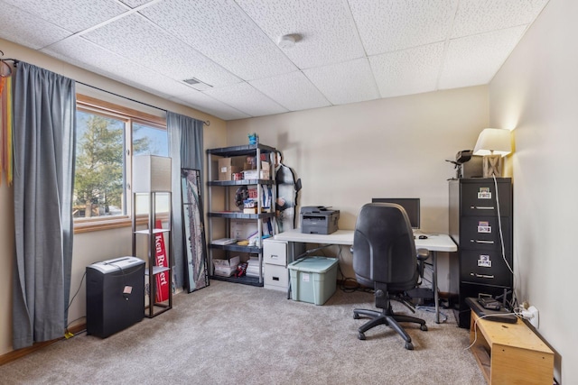 carpeted office space featuring a paneled ceiling