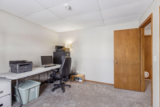 carpeted office with a paneled ceiling