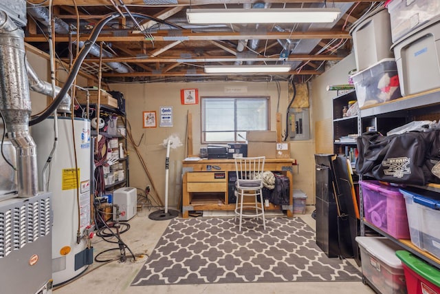 basement featuring a workshop area, water heater, and electric panel