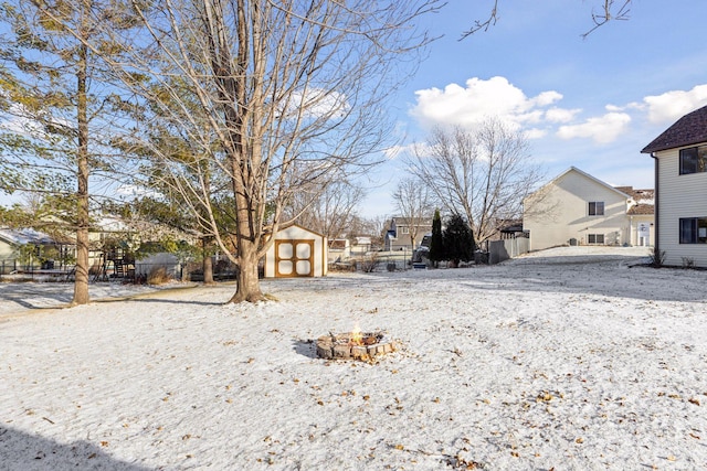 yard covered in snow with a storage unit