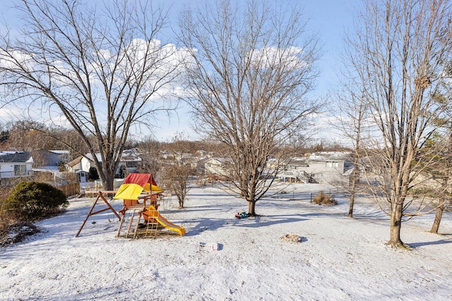 yard covered in snow with a playground