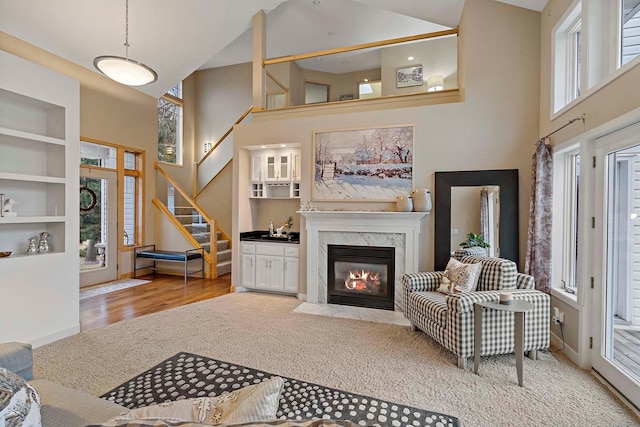 living room with light hardwood / wood-style floors, high vaulted ceiling, and plenty of natural light