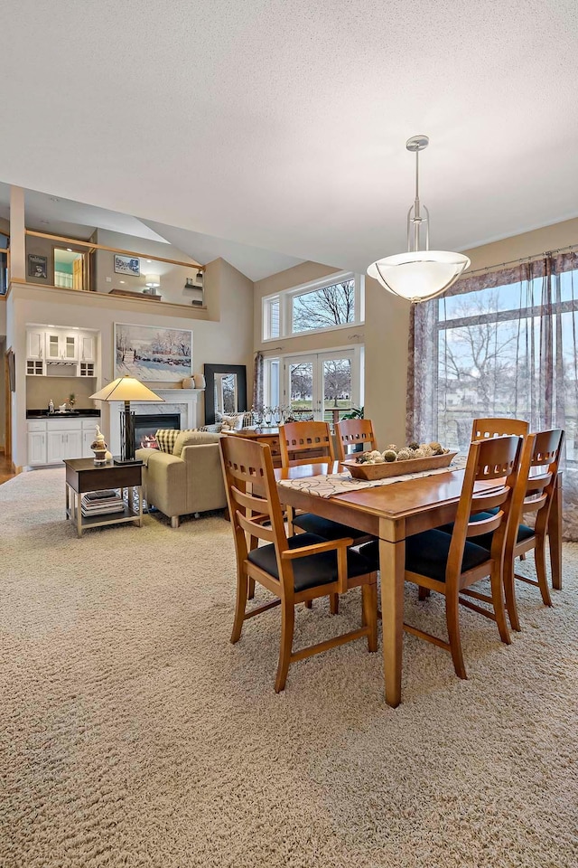 dining space with carpet, french doors, and a textured ceiling