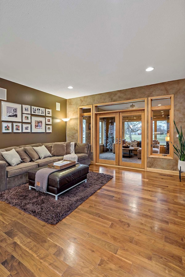 living room featuring french doors, a textured ceiling, and hardwood / wood-style flooring