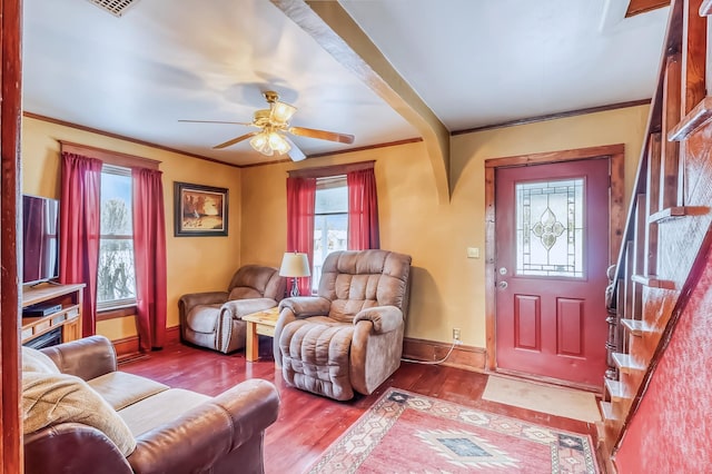 living room featuring ceiling fan, ornamental molding, a wealth of natural light, and light hardwood / wood-style flooring