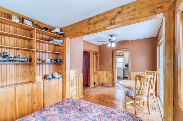 bedroom with light hardwood / wood-style floors and wooden walls