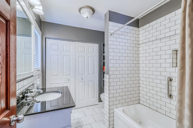 full bathroom with vanity, backsplash, tile patterned floors, tiled shower / bath combo, and toilet