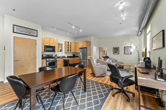 office space featuring light hardwood / wood-style floors, sink, and track lighting