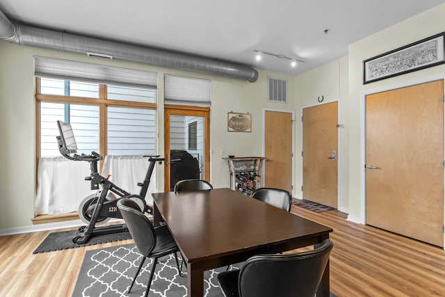 dining space featuring hardwood / wood-style floors and rail lighting