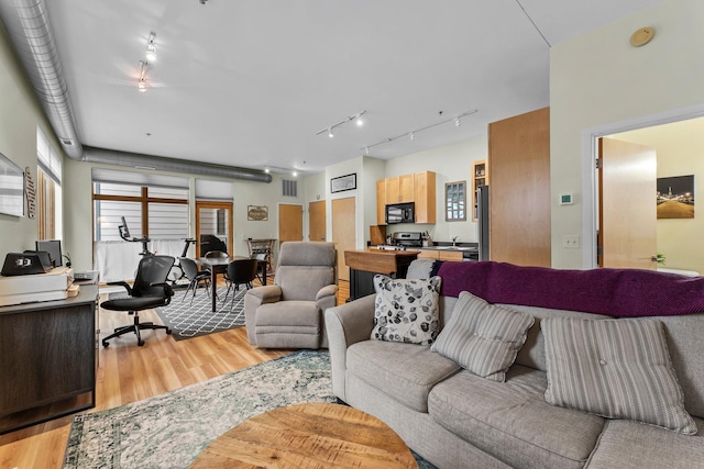 living room with light hardwood / wood-style flooring and sink