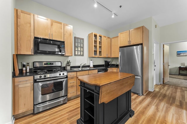 kitchen with sink, light brown cabinets, light hardwood / wood-style floors, track lighting, and appliances with stainless steel finishes