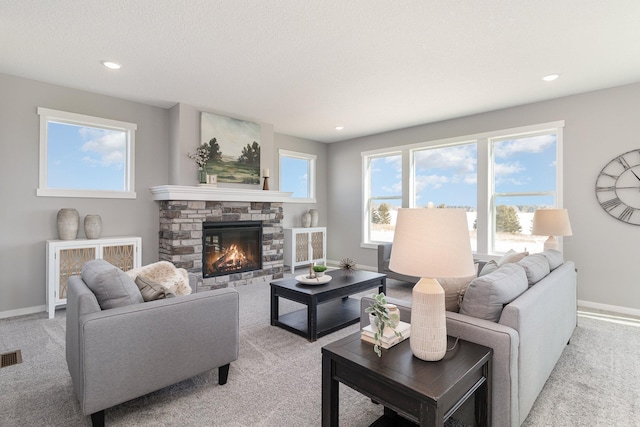 living room featuring light carpet, a stone fireplace, and a textured ceiling