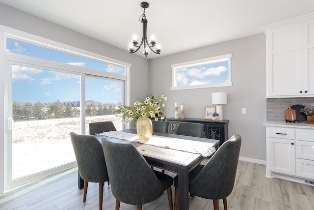 dining area with an inviting chandelier and light wood-type flooring