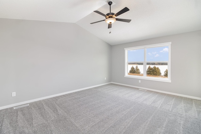 spare room with ceiling fan, lofted ceiling, carpet floors, and a textured ceiling