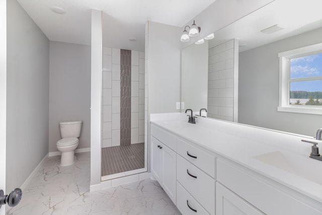 bathroom featuring vanity, toilet, and a tile shower